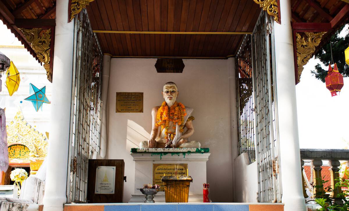 alt="Statue von Jivaka Kumar Bhaccha, dem legendären Begründer der traditionellen Thai-Massage, als Symbol für die alte Heilkunst.