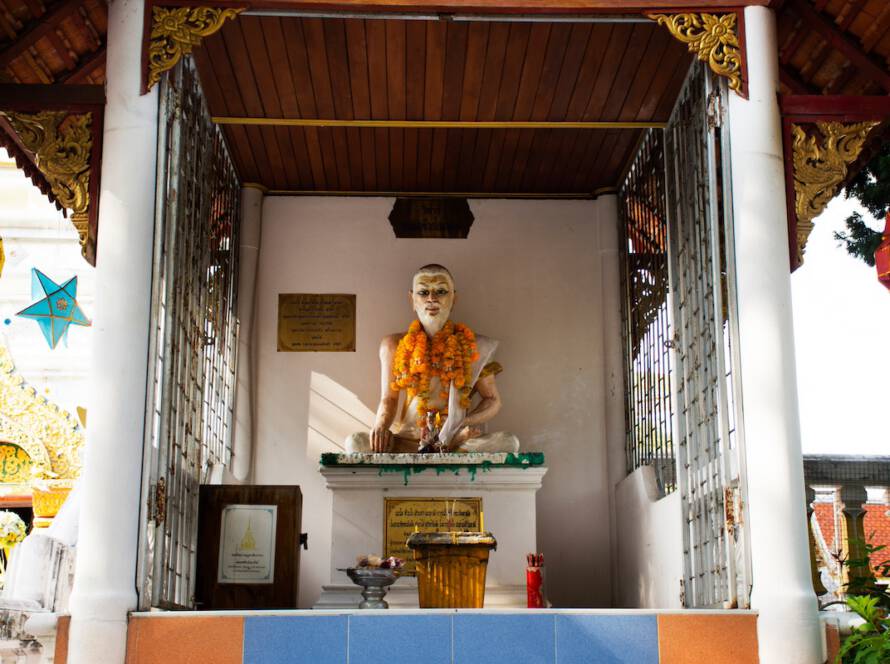alt="Statue von Jivaka Kumar Bhaccha, dem legendären Begründer der traditionellen Thai-Massage, als Symbol für die alte Heilkunst.
